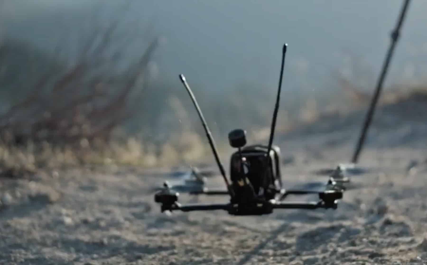 Futuristic autonomous drones speeding through Ohio racecourse under stadium lights at Anduril AI Grand Prix 2026 tournament